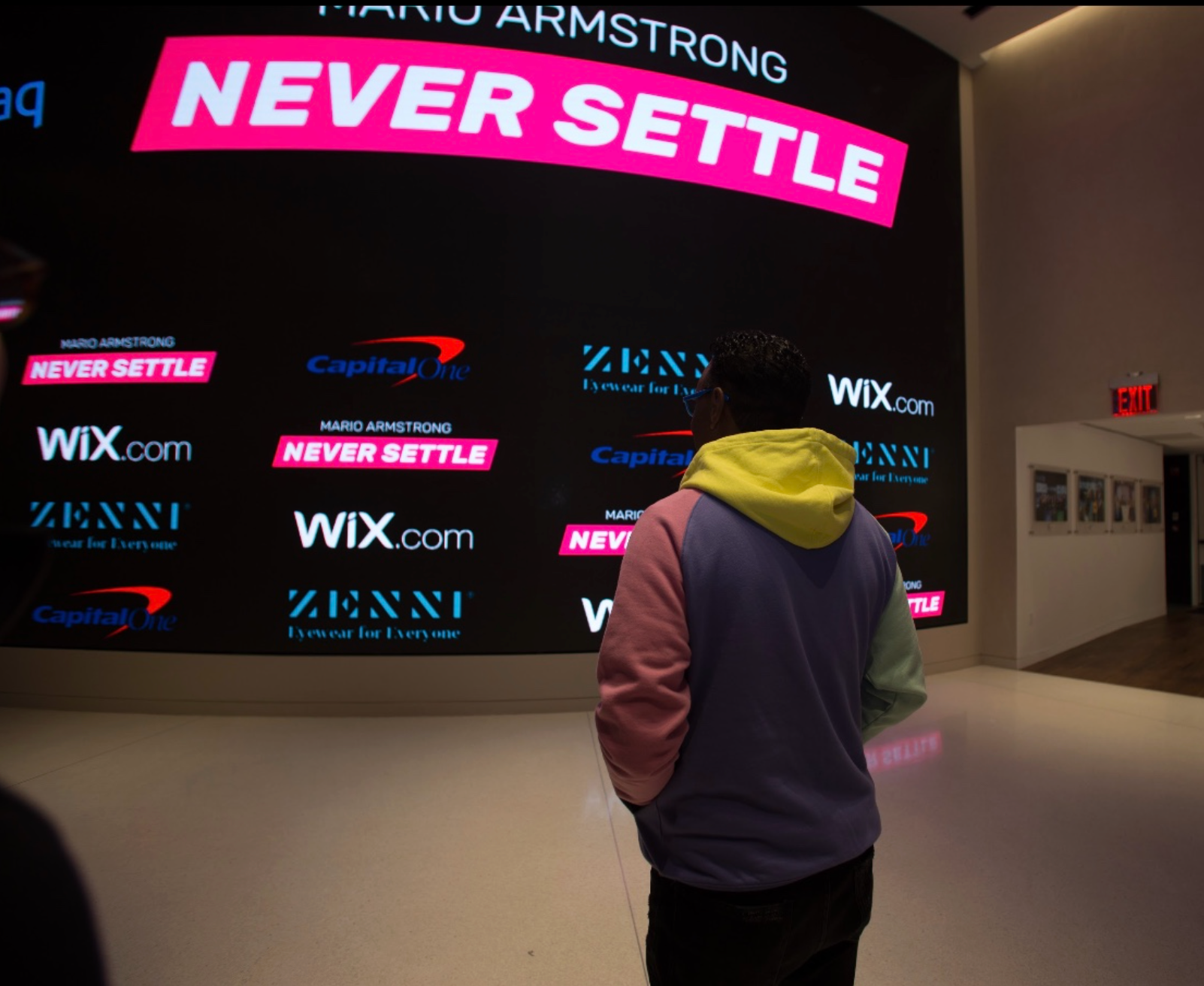 Never Settle Show sponsor wall featuring Capital One, Zenni and Wix